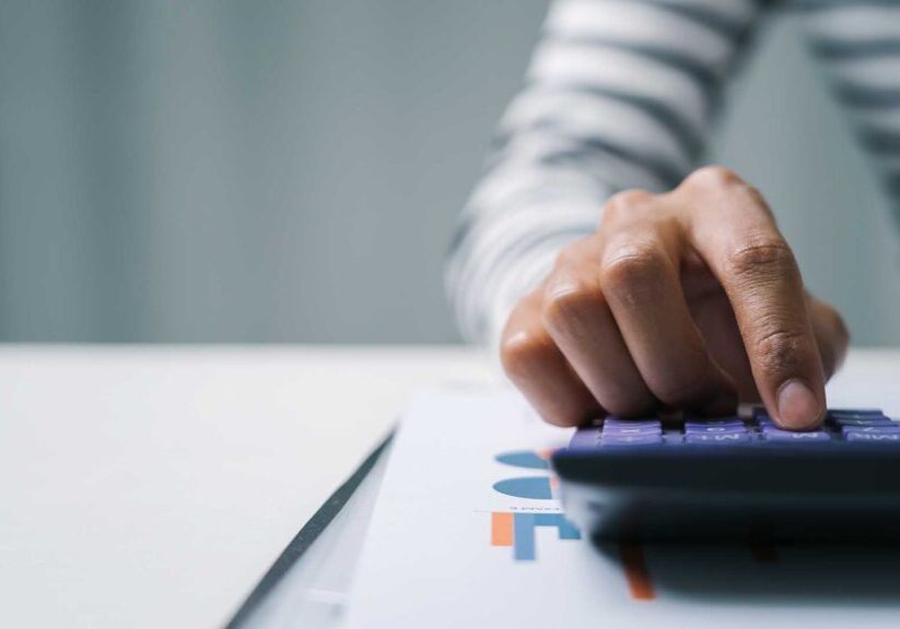 Close up business woman secretary using calculator to do math finance in office with tax accounting statistics research concept.