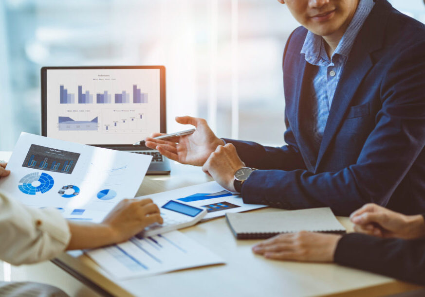 A male business consultant describes a marketing plan to set business strategies for women business owners with using calculator. business planning and business researching concept.